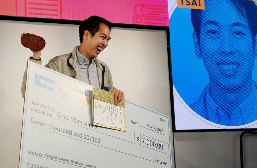 An excited Brandon Tsai holds his winnings after taking first place in Grad Slam 2023